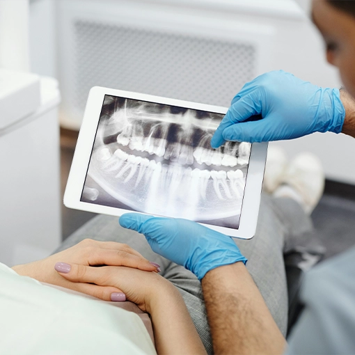 Dentist Pointing To X-Ray On A Tablet